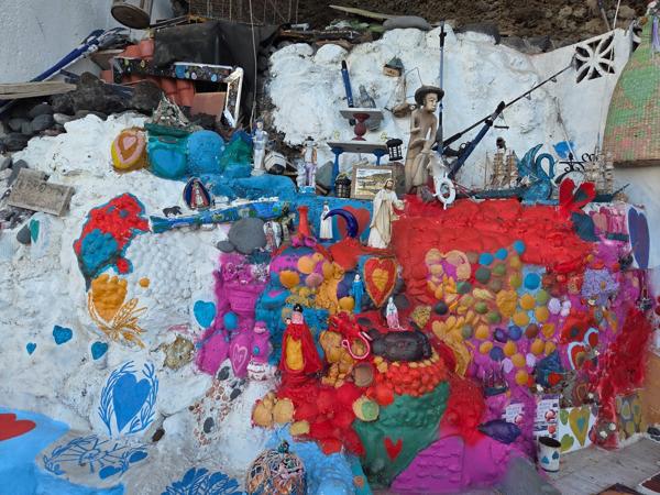 Color y creatividad en los muros del pueblo Pared decorada con murales y objetos reciclados