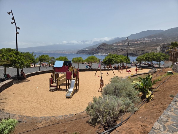 Parque infantil junto a la playa Zona infantil con columpios y toboganes junto al mar en la playa de Radazul, ideal para familias con niños.